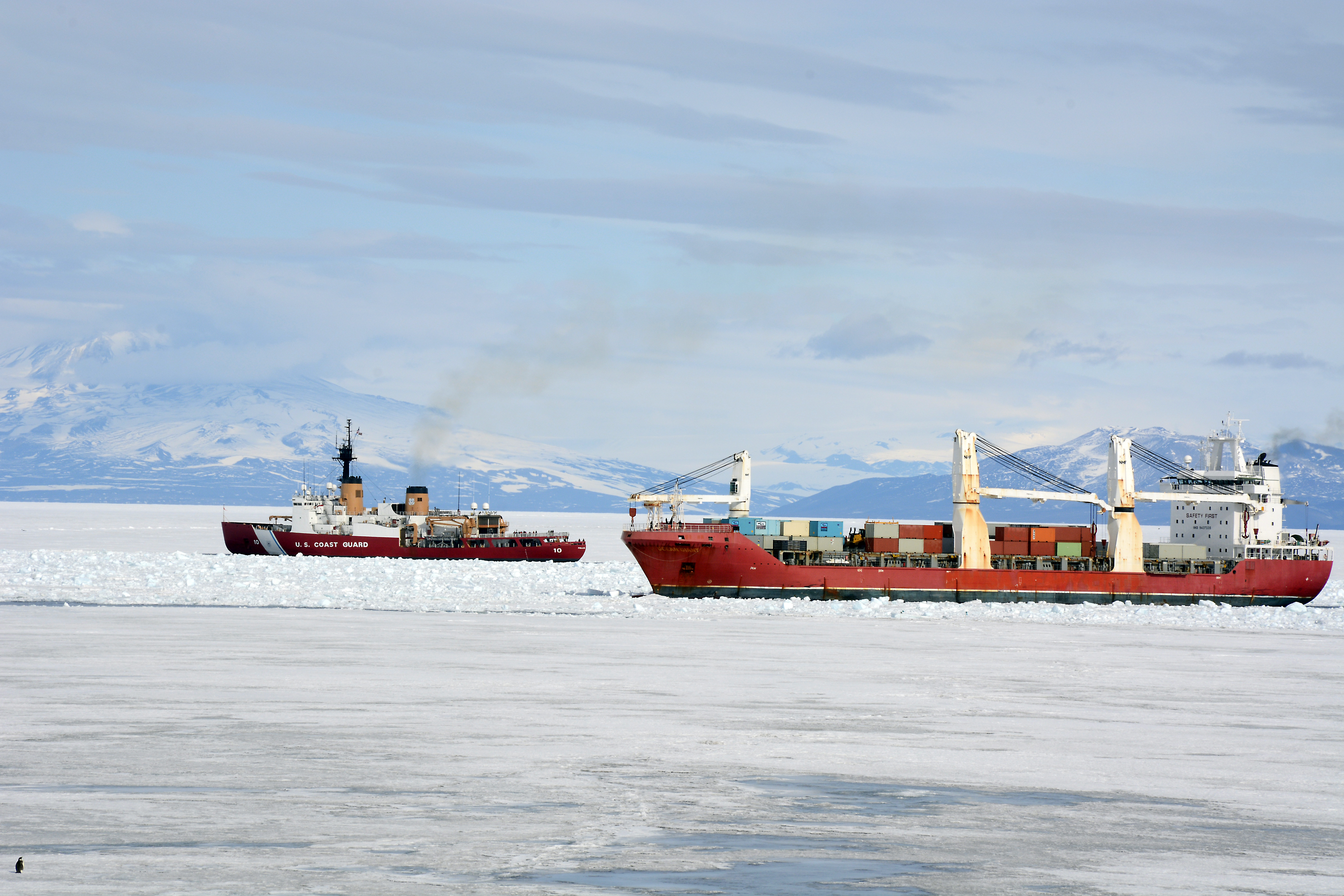 Two ships sail through ice.