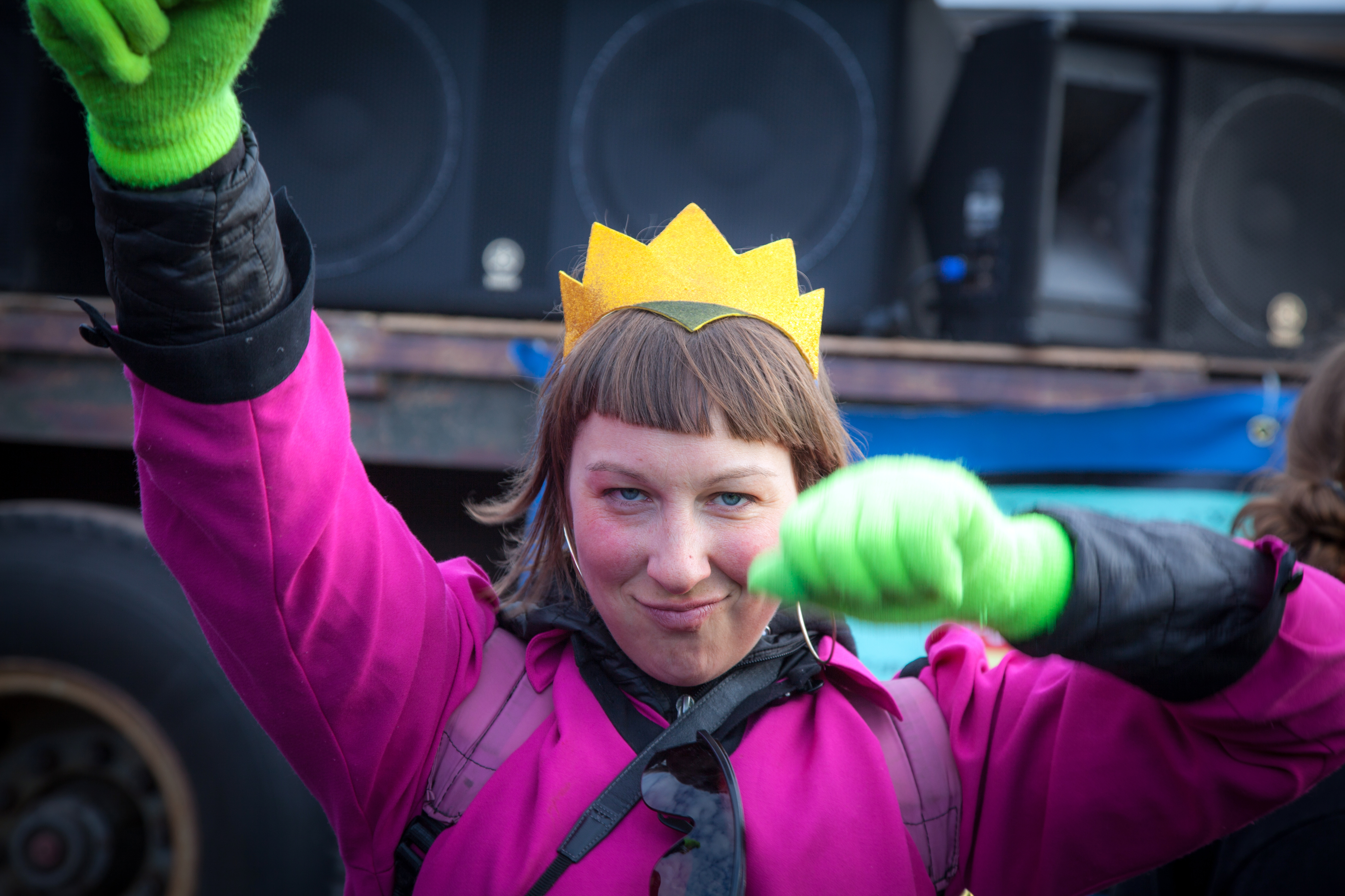 Person in costume dances in front of speakers.