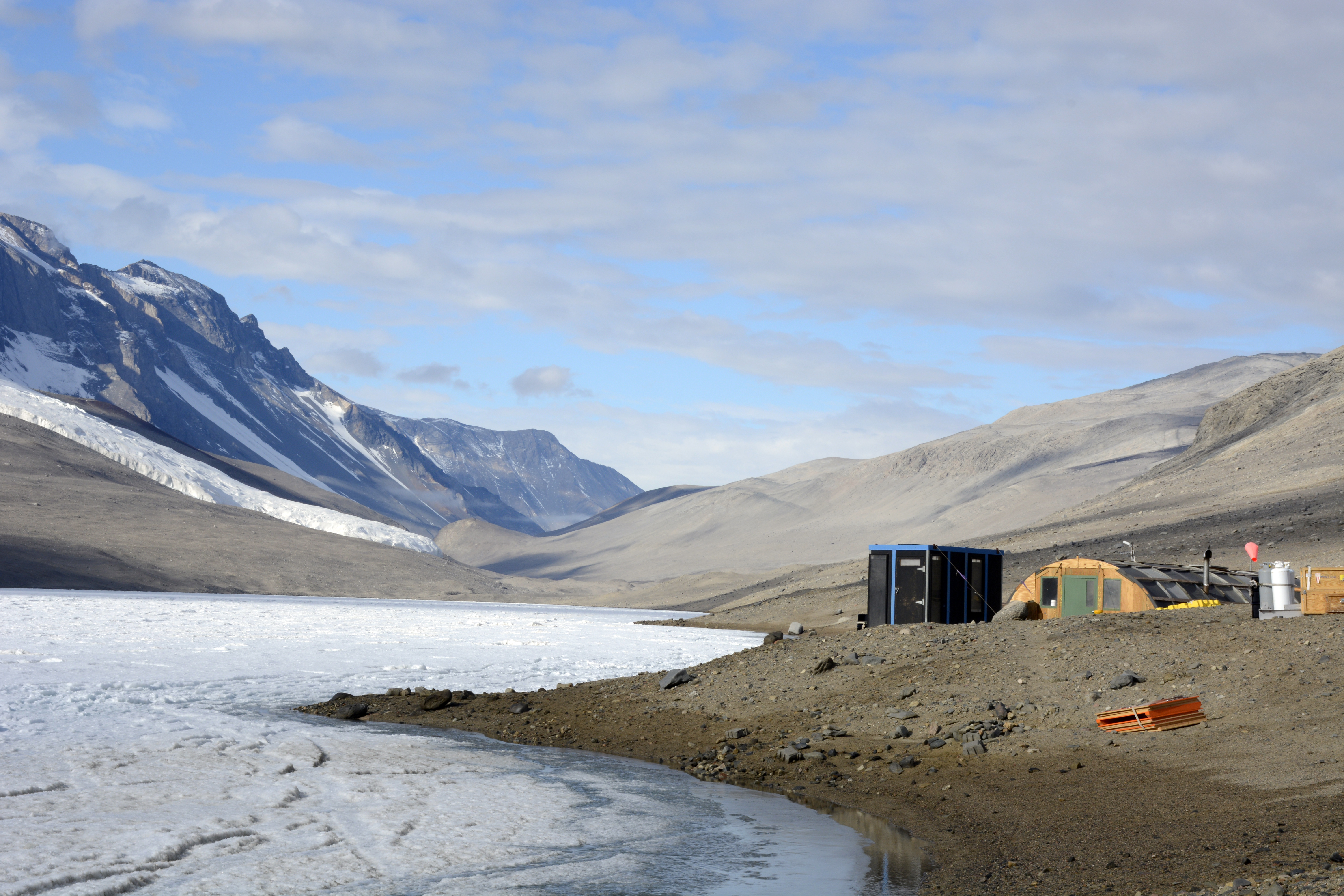 Buildings sit on the shore of an ice-covered lake.