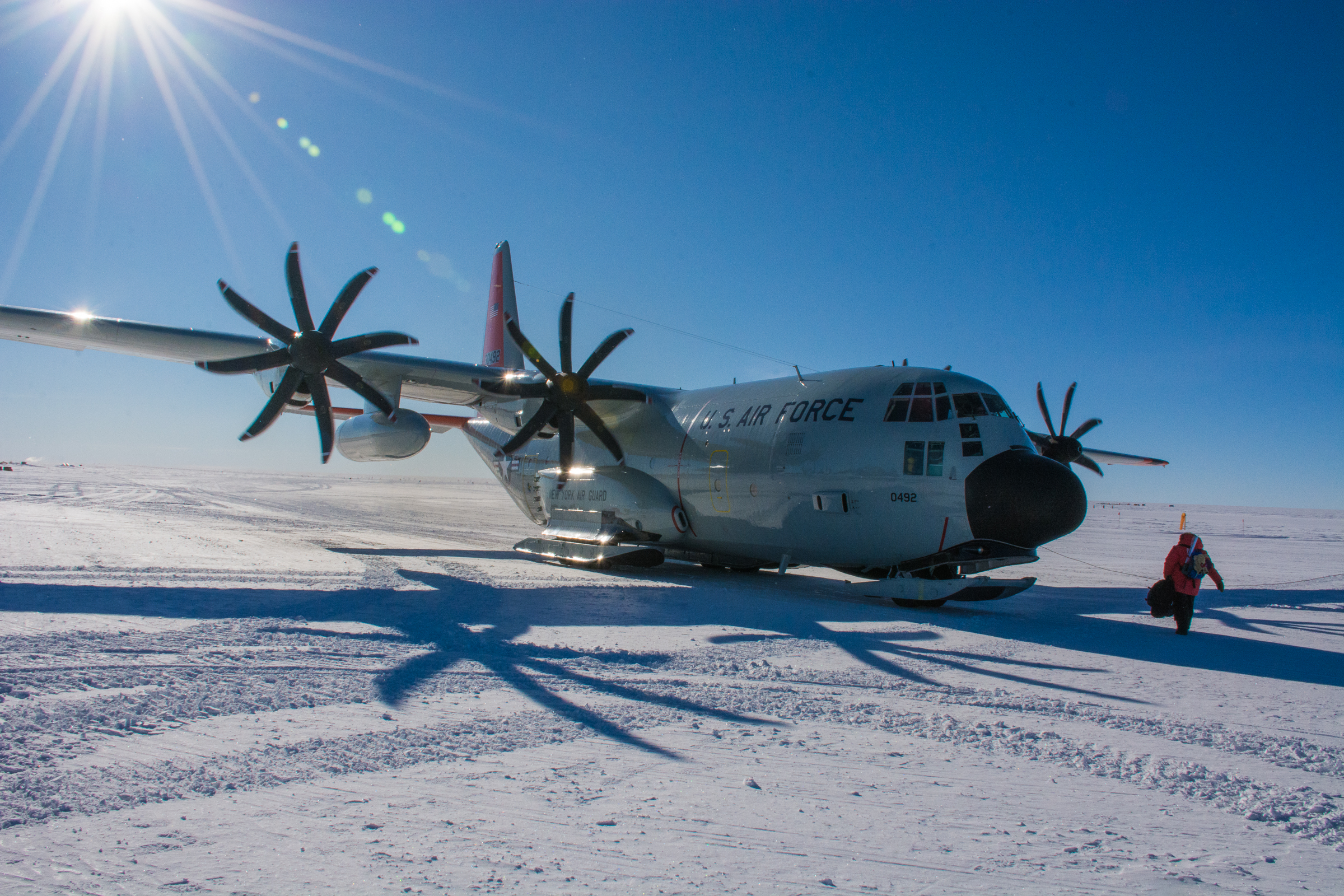 A person walks toward an aircraft on snow.