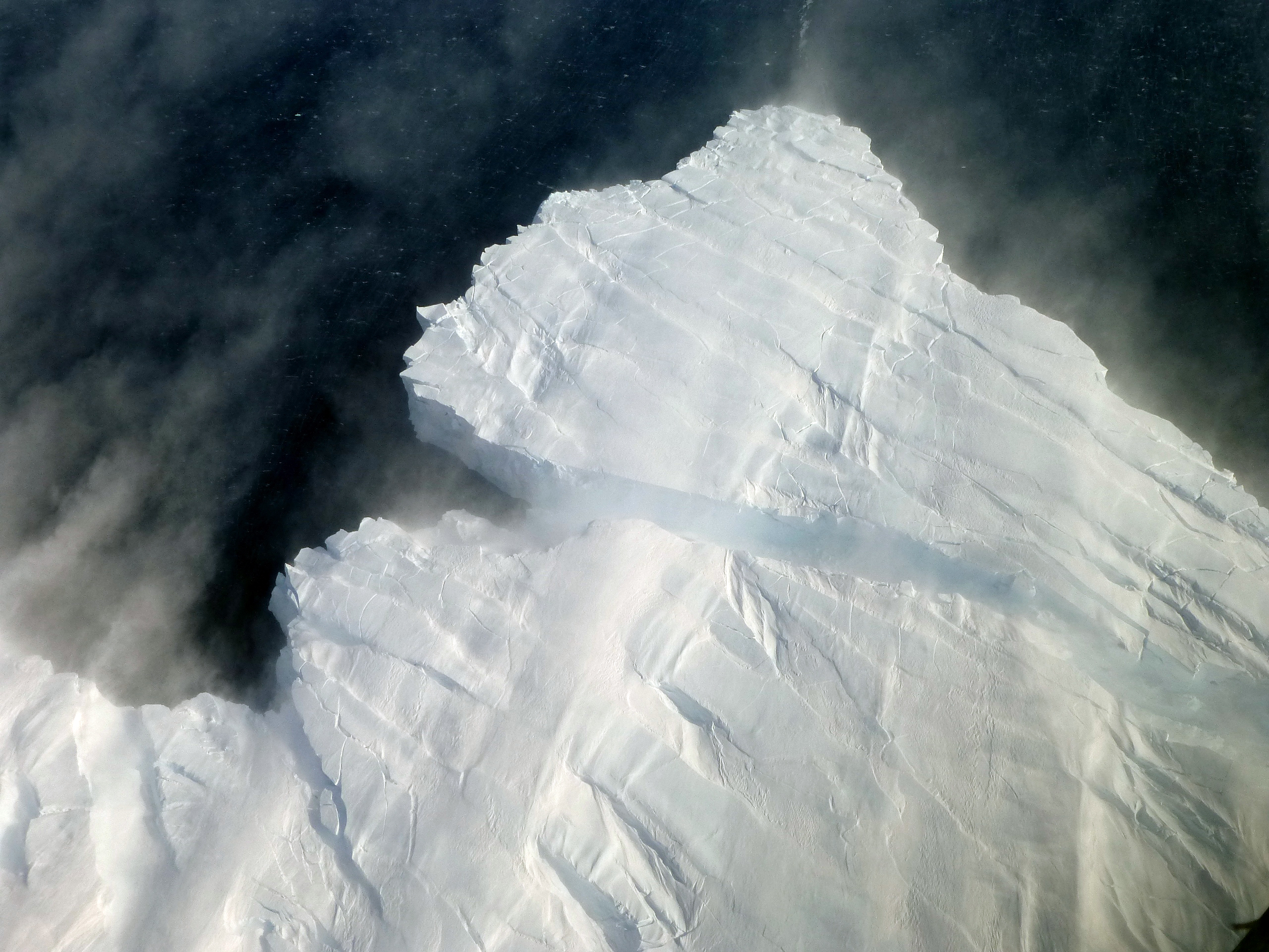 Iceberg calves from ice shelf.