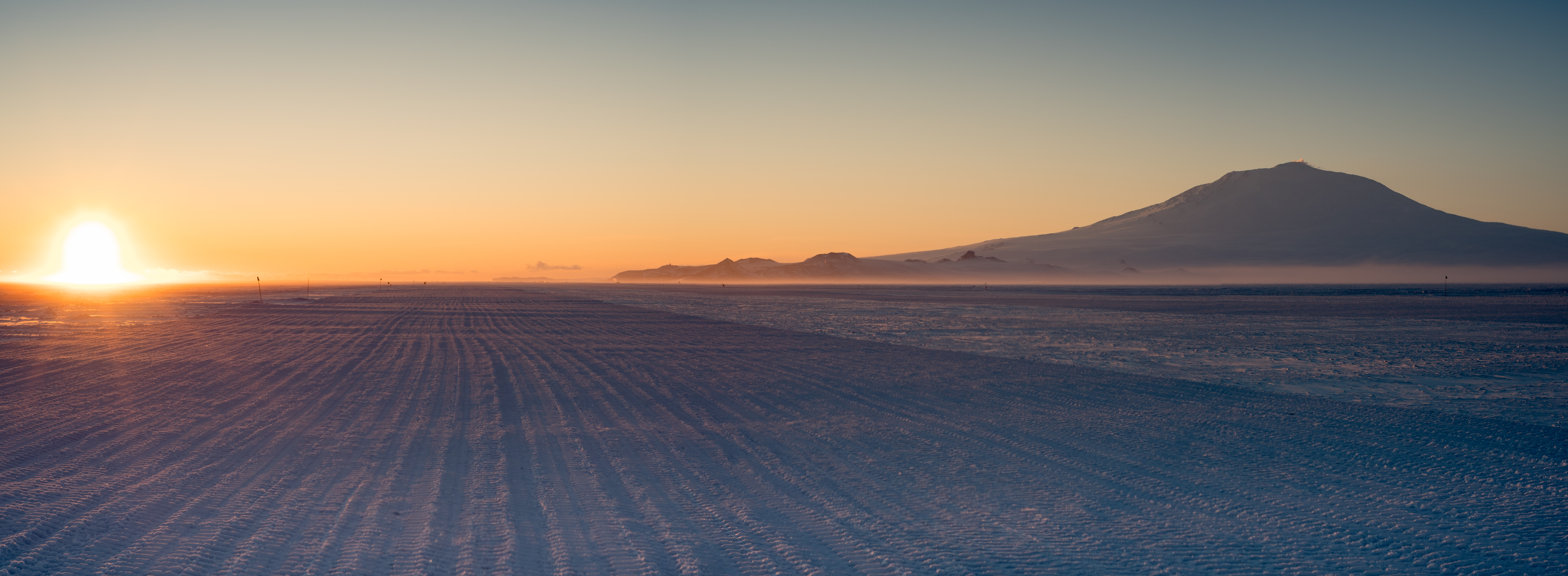 Sunset over a snow covered land.