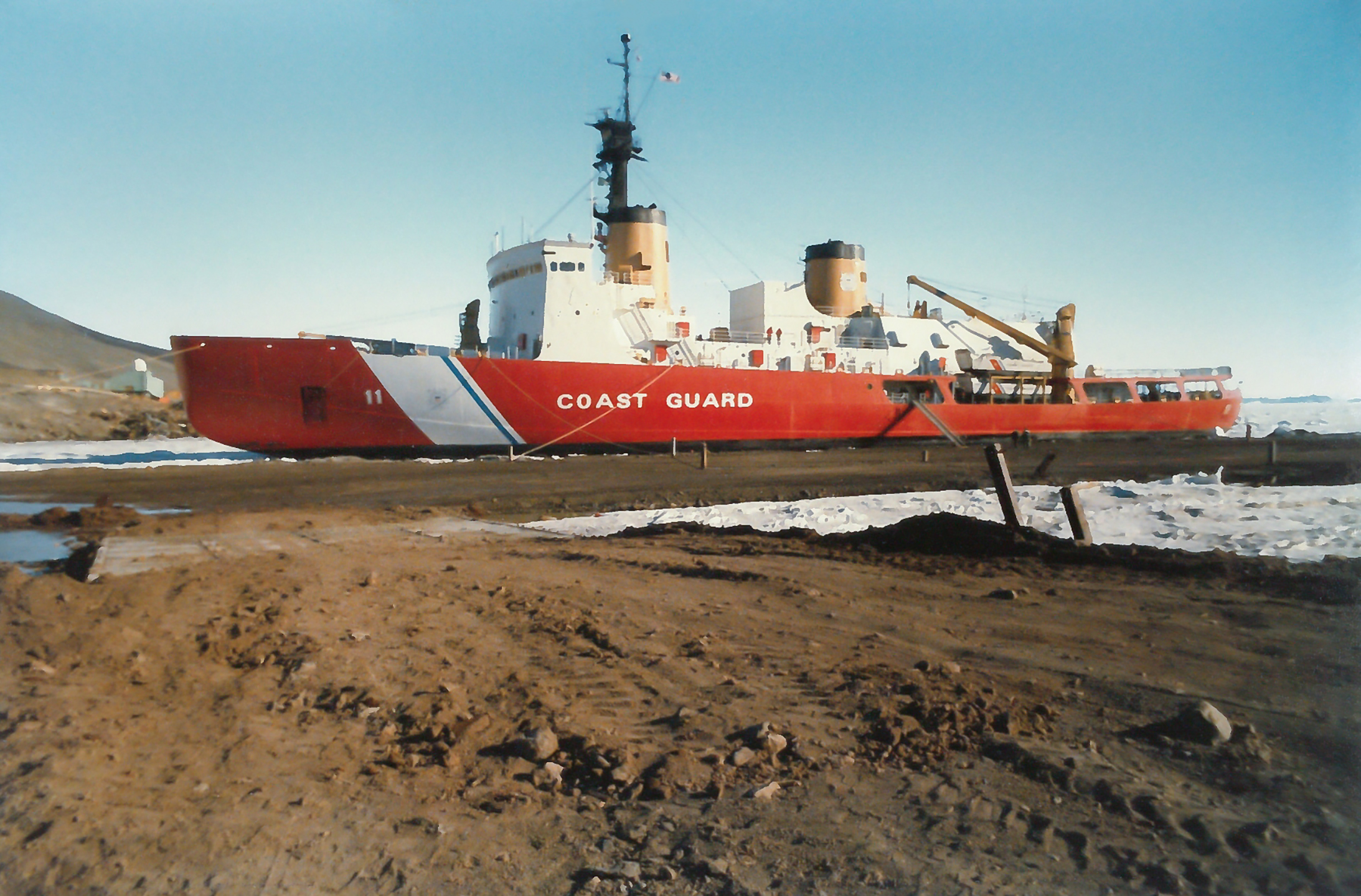 A red vessel docked at a pier.