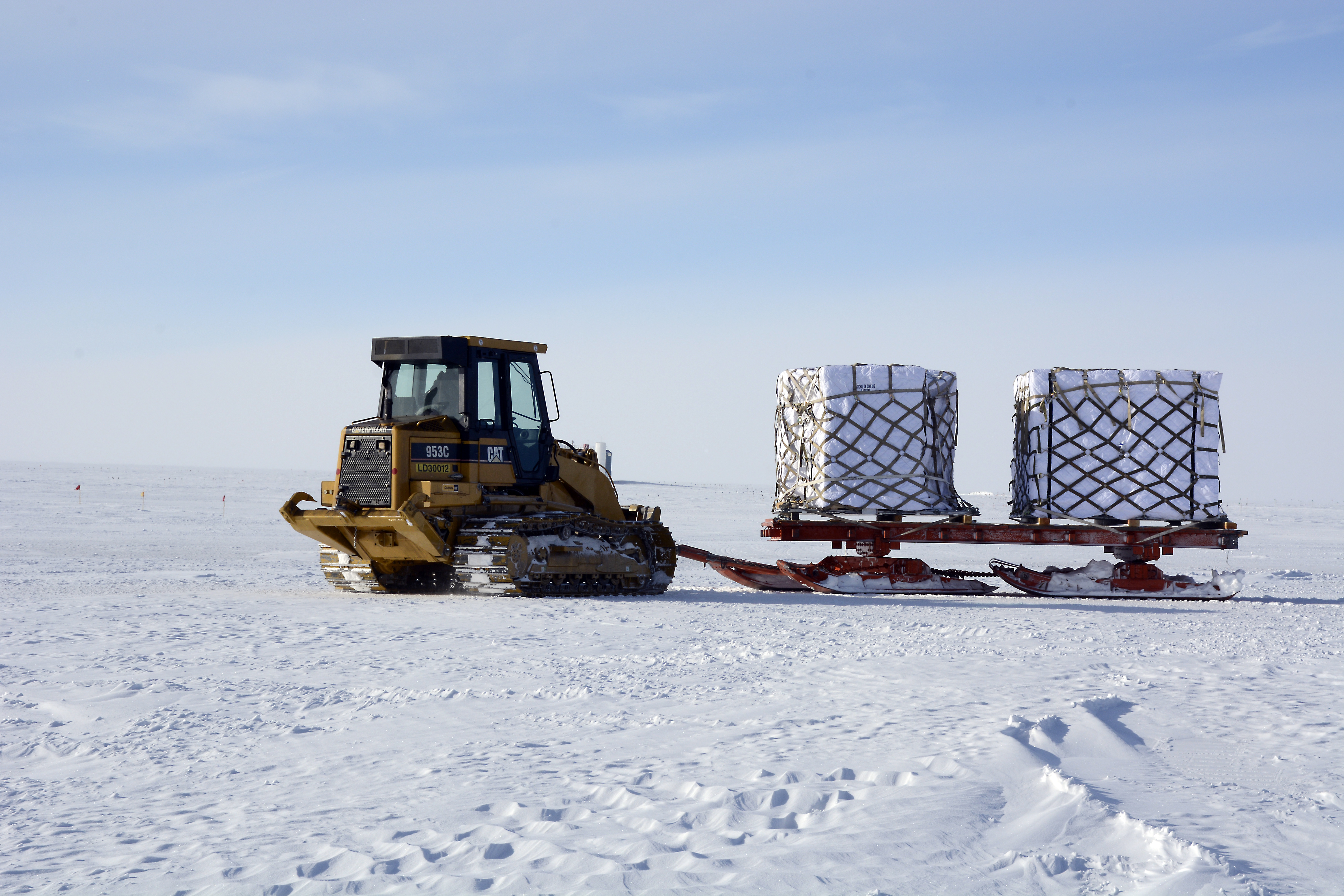 A tractor pulling a large sled with cargo on it.