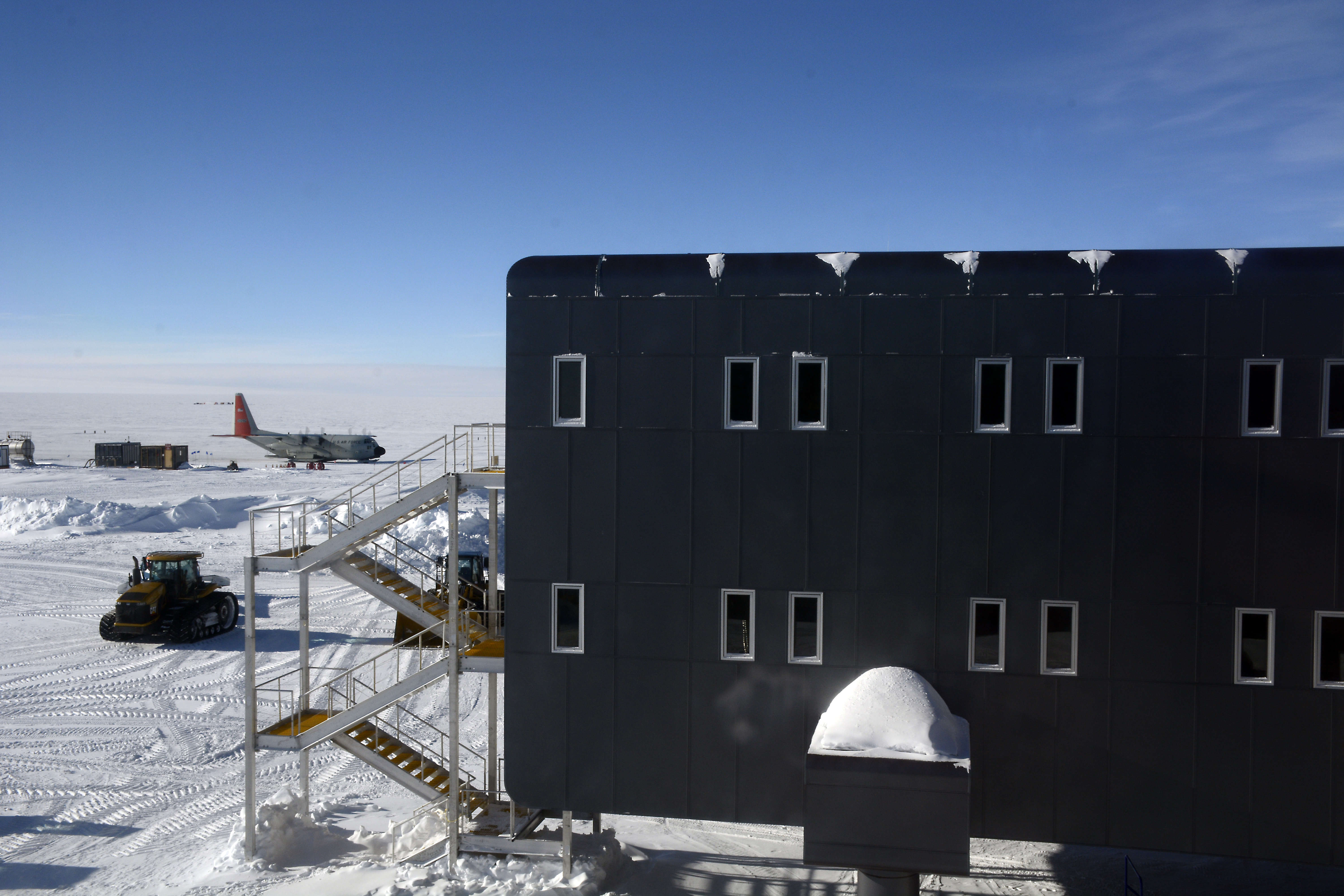 An airplane in the distance on snowy terrain.