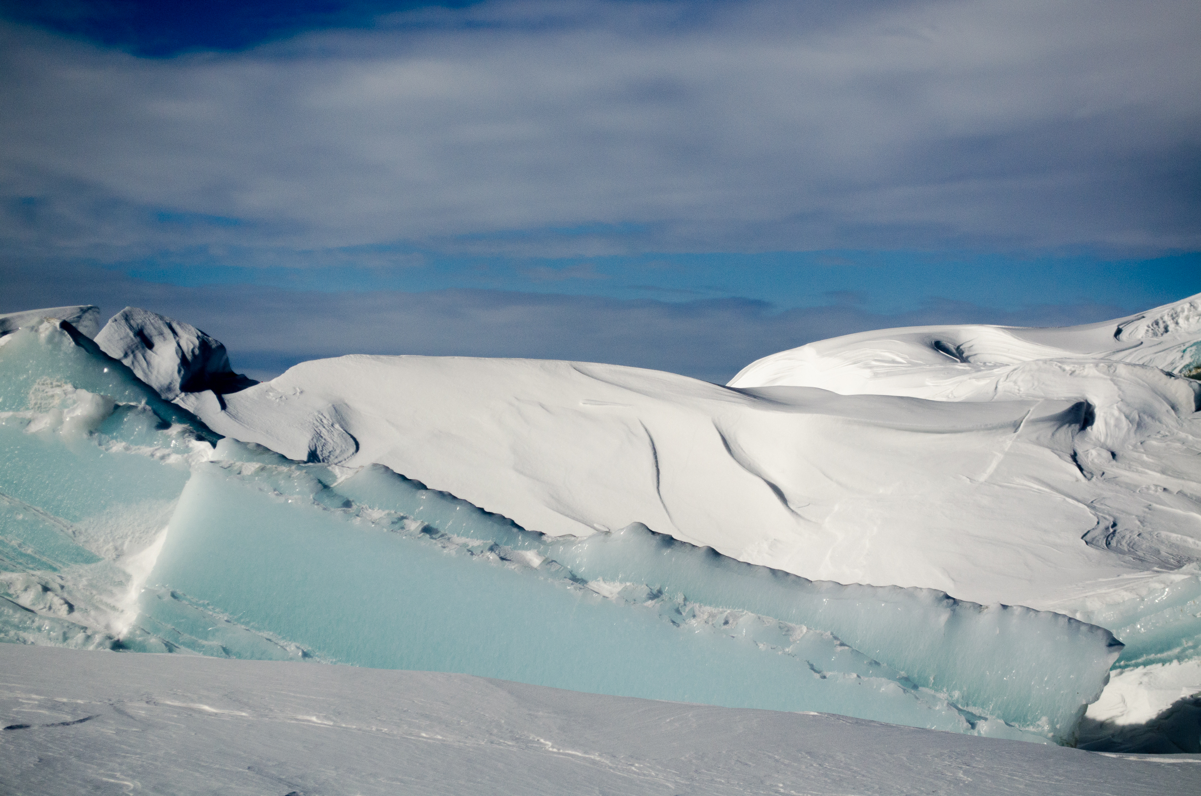 Pressure ridges of snow are pushed up when moving sea ice pushes against stable ice.