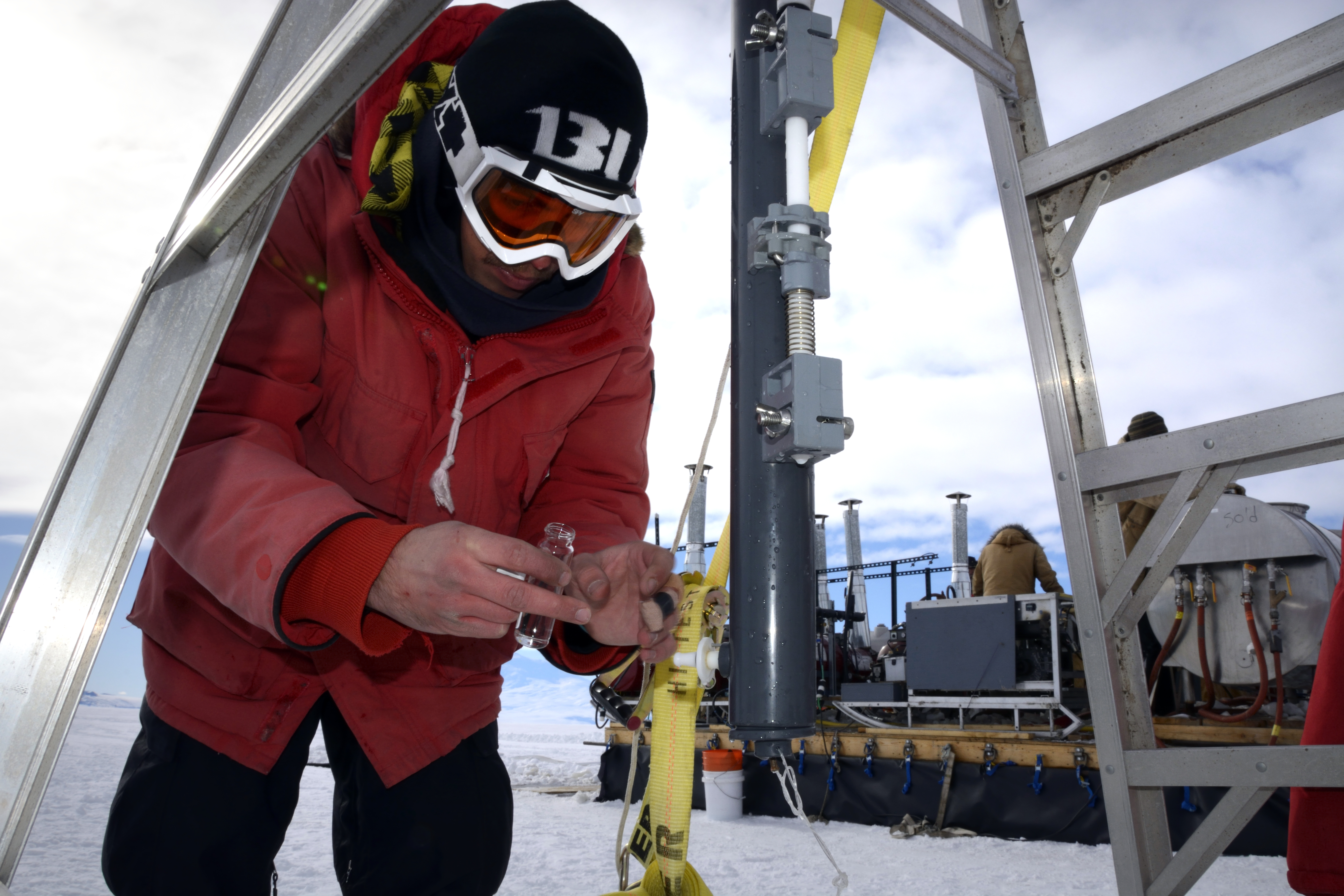 Person leans over to gather a sample from an instrument.