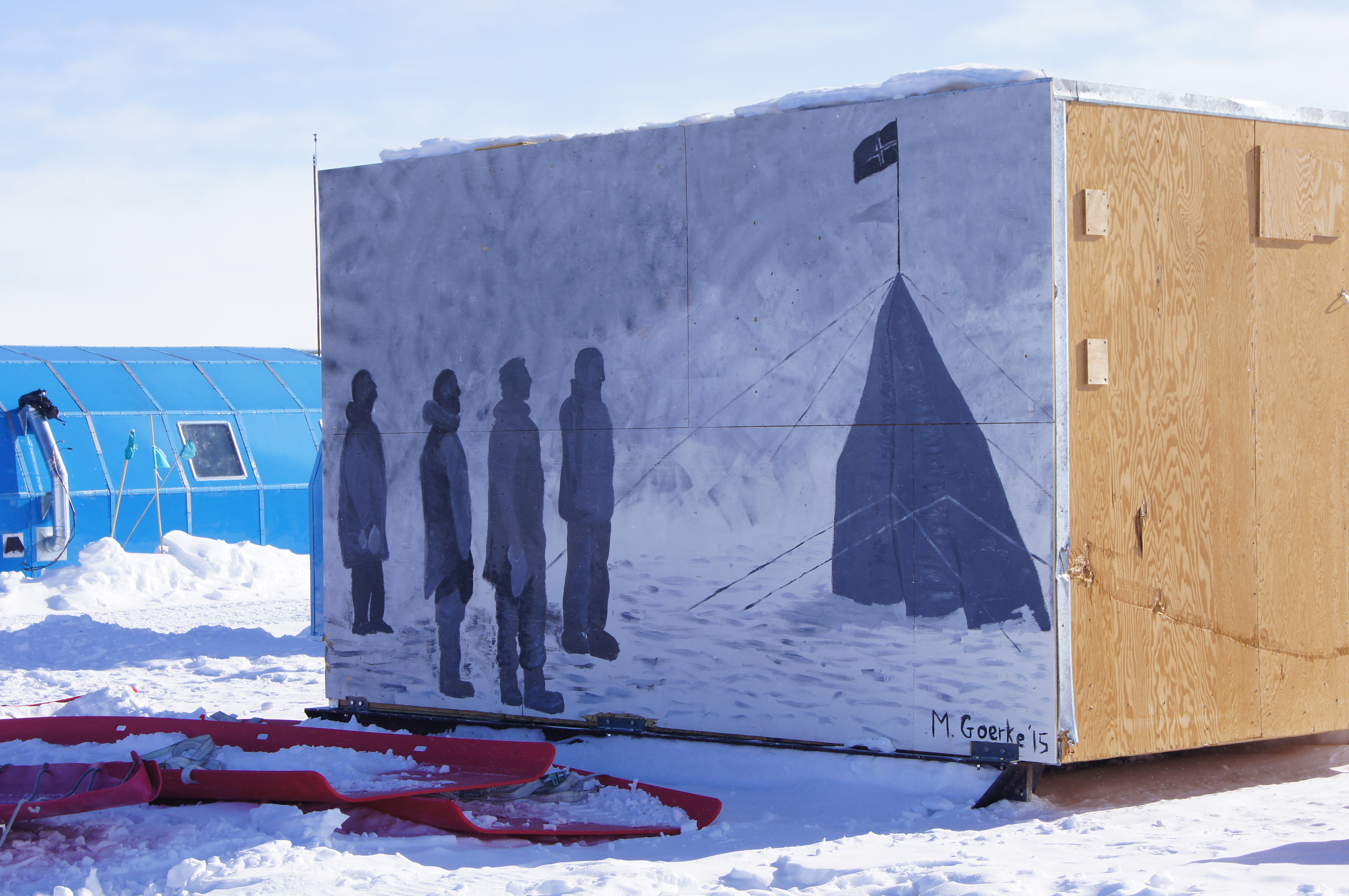 A mural of an iconic scene from Antarctic history appears on the side of a building.