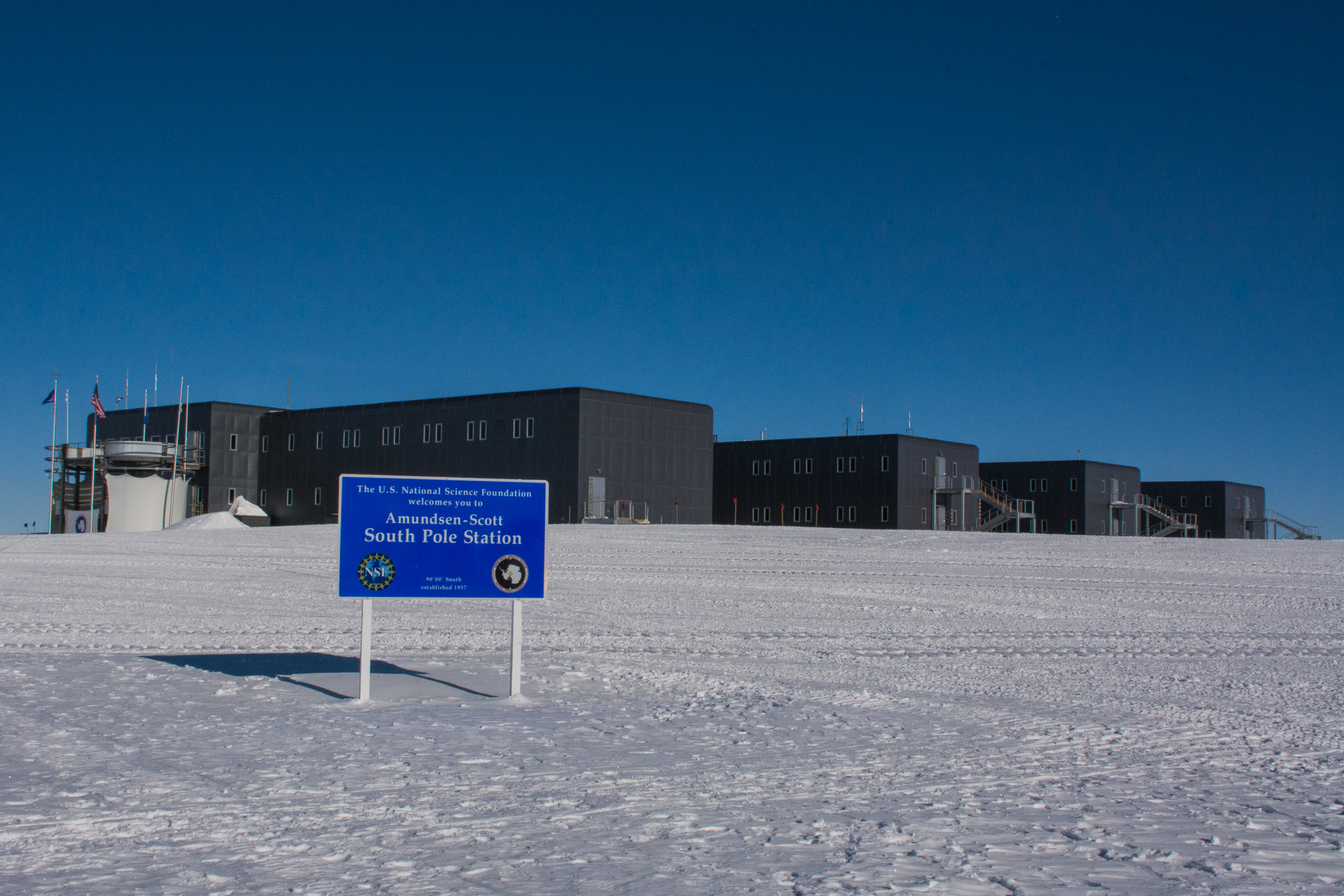 Blue sign stands in front of building.