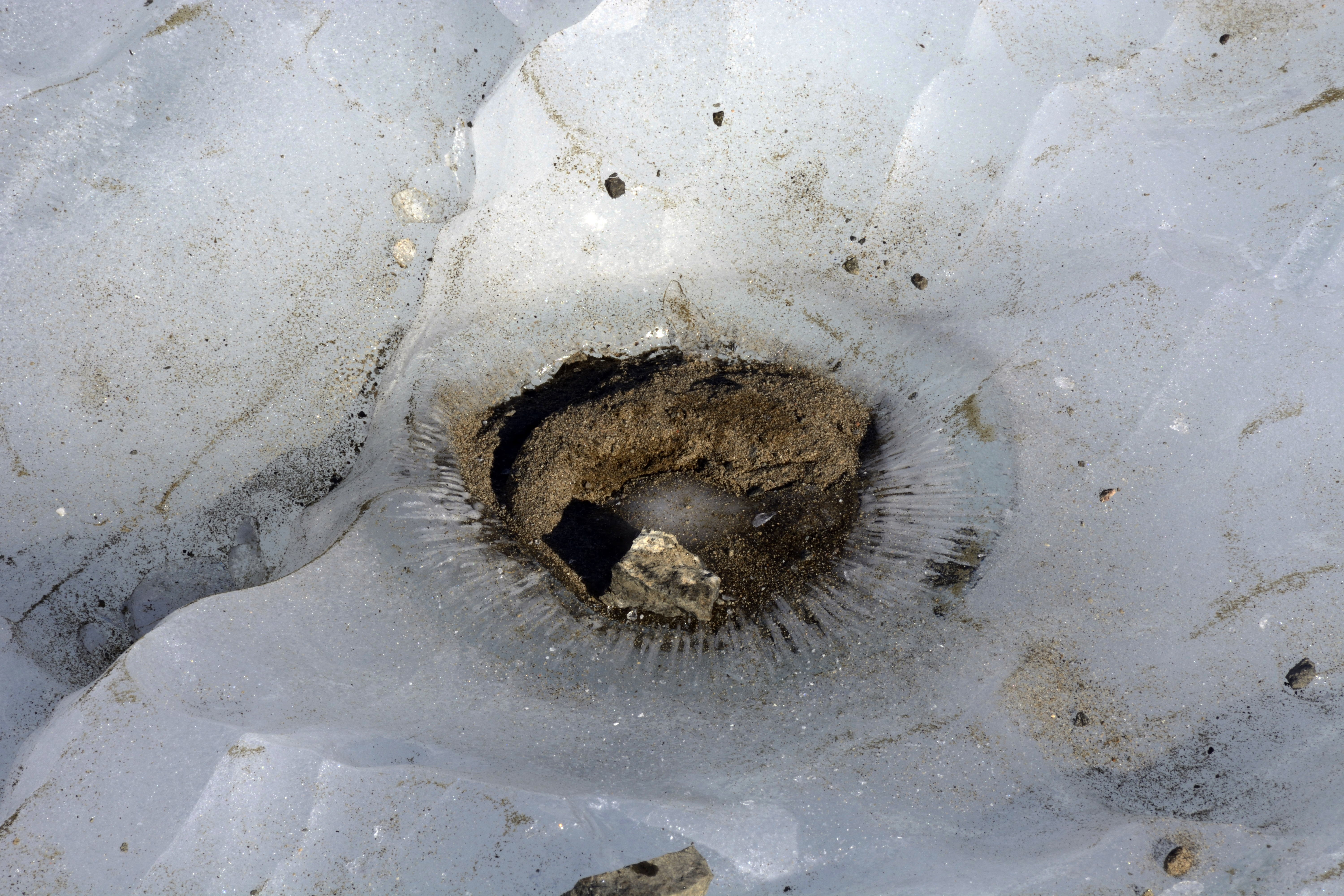 Dirt fills ice-covered hole.