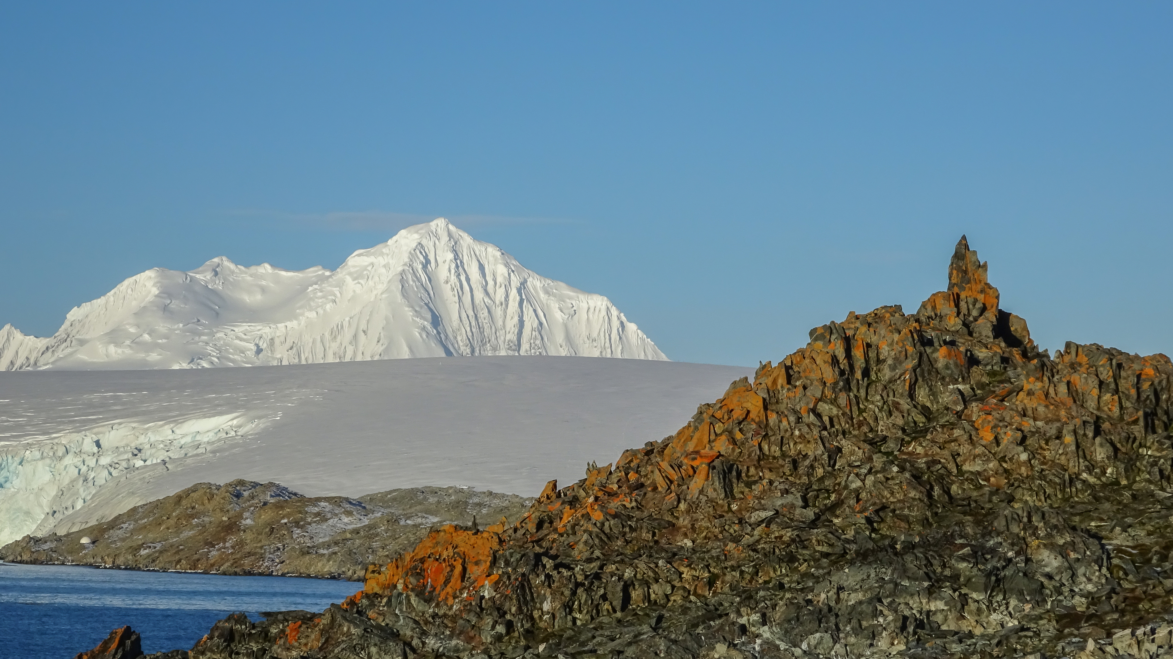 A landscape of a snow-covered mountain and craggy rocks.