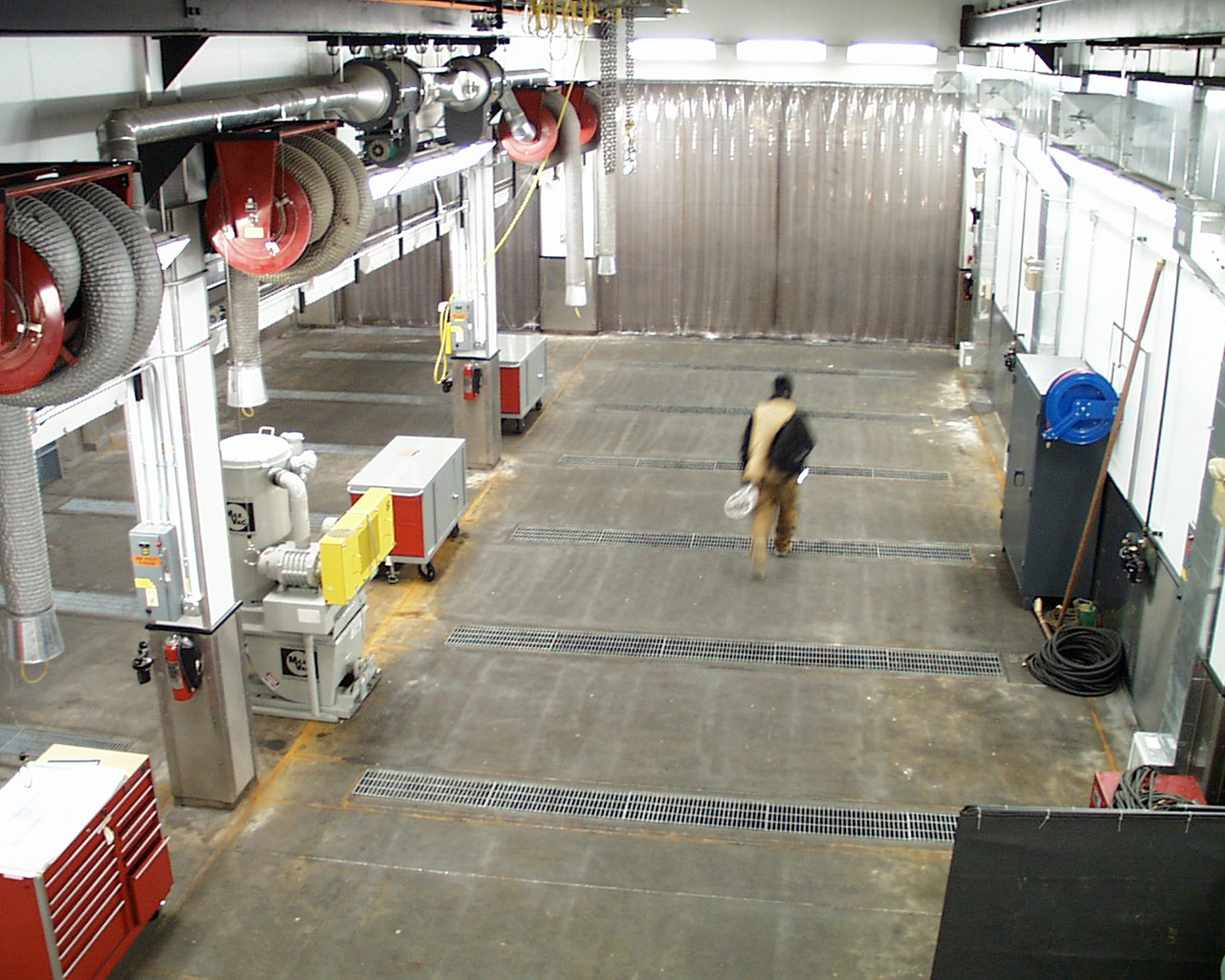 A lone man walks through a large building.